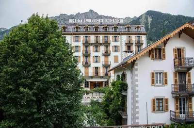 a hotel in the mountains with trees in front of it at Lutetia Apartment - Chamonix All Year in Chamonix-Mont-Blanc