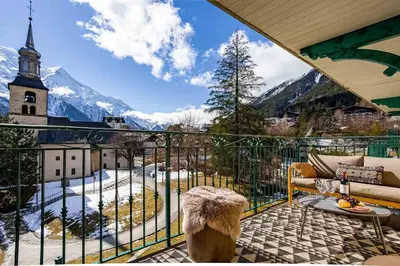 a balcony with a view of a church and mountains at Le Panoramic Mont Blanc Apartment - Chamonix All Year in Chamonix-Mont-Blanc