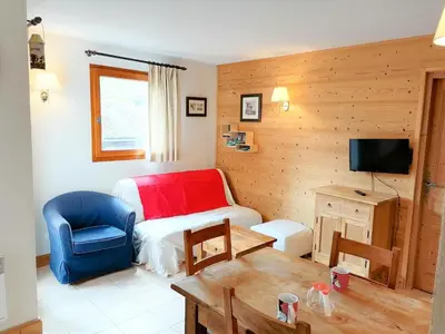 a room with a bed and a chair and a table at Appartement 3 pièces à Morillon 1100, 6 personnes, animaux admis, wifi - FR-1-815-72 in Morillon