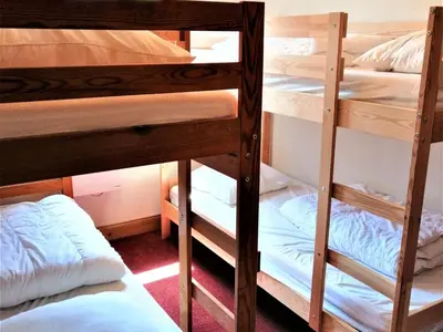 a bed in a room with wooden cabinets at Appartement 3 pièces à Morillon 1100, 6 personnes, animaux admis, wifi - FR-1-815-72 in Morillon
