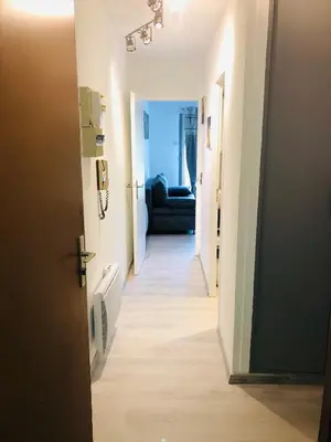 a hallway leading to a room with a blue couch at Le petit Chamois in Saint-Gervais-les-Bains