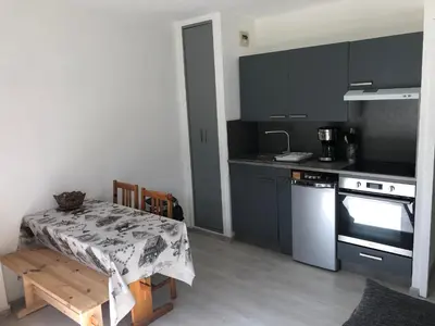 a kitchen with black cabinets and a table and a stove at Le petit Chamois in Saint-Gervais-les-Bains