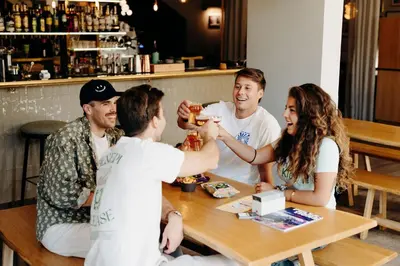 a group of people sitting around a table with drinks at PlanB Hotel - Living Chamonix in Chamonix-Mont-Blanc