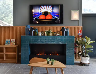a living room with a fireplace and a table at PlanB Hotel - Living Chamonix in Chamonix-Mont-Blanc
