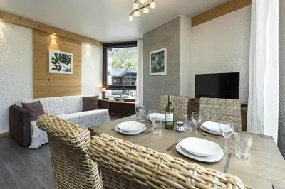 a dining room with a wooden table and chairs at APARTMENT BEAUSITE - Alpes Travel - Central Chamonix - Sleeps 2-4 in Chamonix-Mont-Blanc