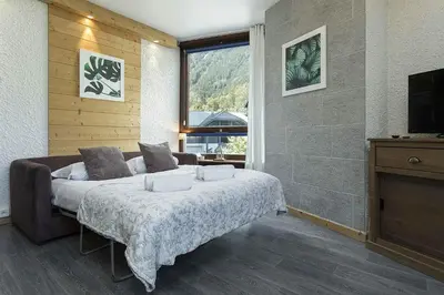 a bedroom with a large bed and a television at APARTMENT BEAUSITE - Alpes Travel - Central Chamonix - Sleeps 2-4 in Chamonix-Mont-Blanc