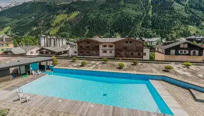 an overhead view of a swimming pool with mountains in the background at APARTMENT BEAUSITE - Alpes Travel - Central Chamonix - Sleeps 2-4 in Chamonix-Mont-Blanc
