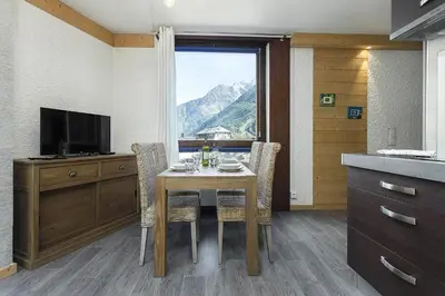 a kitchen with a table with chairs and a television at APARTMENT BEAUSITE - Alpes Travel - Central Chamonix - Sleeps 2-4 in Chamonix-Mont-Blanc