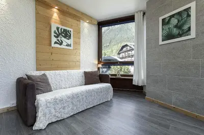 a living room with a couch and a window at APARTMENT BEAUSITE - Alpes Travel - Central Chamonix - Sleeps 2-4 in Chamonix-Mont-Blanc