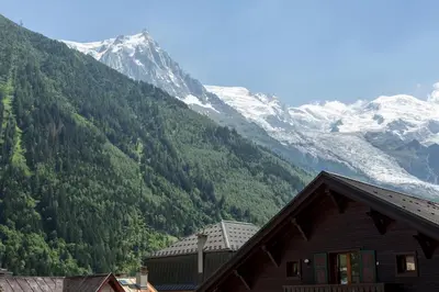 a house in front of a mountain with snow at Apartment Blanc Neige 2 - Centre de Chamonix in Chamonix-Mont-Blanc