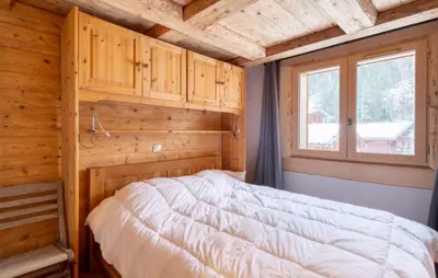 a bedroom with a bed in a wooden room at Home sweet home in Chamonix-Mont-Blanc