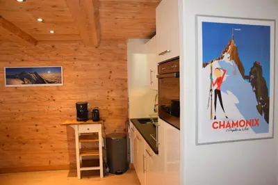 a kitchen with wooden walls and a poster on the wall at Home sweet home in Chamonix-Mont-Blanc