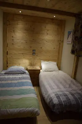 two beds in a room with a wooden wall at Home sweet home in Chamonix-Mont-Blanc