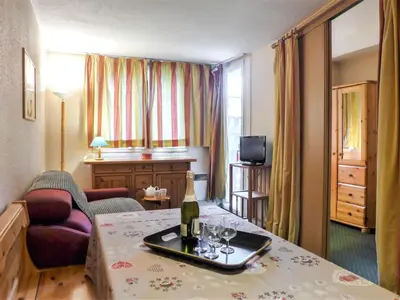 a hotel room with a bottle of wine on a table at Apartment Jonquilles-10 by Interhome in Chamonix-Mont-Blanc