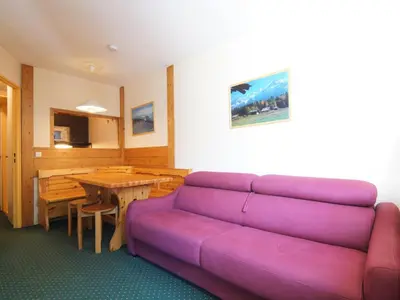 a living room with a purple couch and a table at Apartment Jonquilles-10 by Interhome in Chamonix-Mont-Blanc