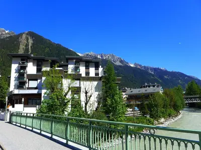 a building on a bridge next to a river at Studio L'Aiguille du Midi-8 by Interhome in Chamonix-Mont-Blanc
