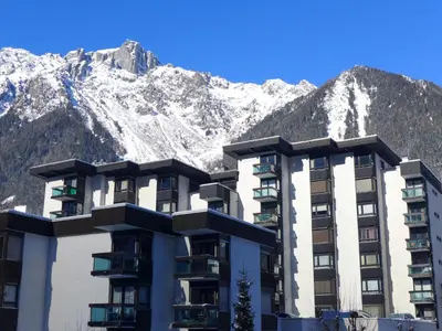 a building with mountains in the background at Studio L'Aiguille du Midi-8 by Interhome in Chamonix-Mont-Blanc
