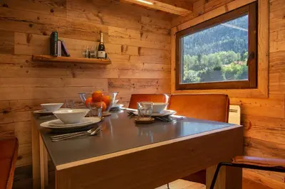 a dining table in a cabin with a window at Mazot du Mont-Blanc - Happy Rentals in Chamonix-Mont-Blanc