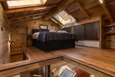 a bedroom with a bed in a room with wooden floors at Mazot du Mont-Blanc - Happy Rentals in Chamonix-Mont-Blanc