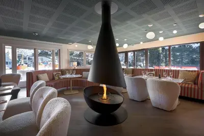 a restaurant with chairs and a table and a lamp at Lykke Hôtel & Spa Chamonix - ex Mercure in Chamonix-Mont-Blanc