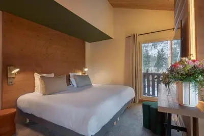 a bedroom with a large bed and a window at Lykke Hôtel & Spa Chamonix - ex Mercure in Chamonix-Mont-Blanc