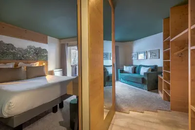 a bedroom with a bed and a living room at Lykke Hôtel & Spa Chamonix - ex Mercure in Chamonix-Mont-Blanc