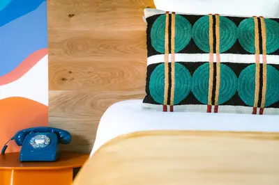 a blue alarm clock sitting on top of a bed at Big Sky Hotel & Spa in Chamonix-Mont-Blanc