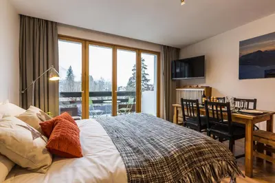 a bedroom with a bed and a table and a desk at Apartment Periades - Central Chamonix Incredible Mountain Views in Chamonix-Mont-Blanc
