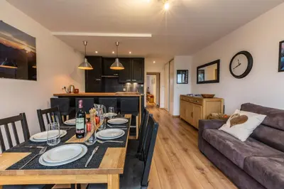 a dining room and living room with a table and a couch at Apartment Periades - Central Chamonix Incredible Mountain Views in Chamonix-Mont-Blanc