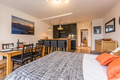 a bedroom with a bed and a kitchen with a table at Apartment Periades - Central Chamonix Incredible Mountain Views in Chamonix-Mont-Blanc