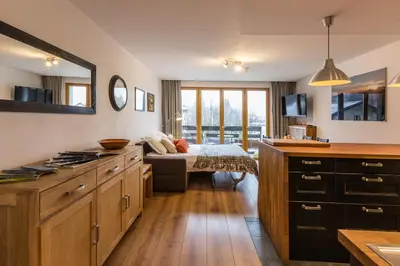 a kitchen with a bed in the middle of a room at Apartment Periades - Central Chamonix Incredible Mountain Views in Chamonix-Mont-Blanc