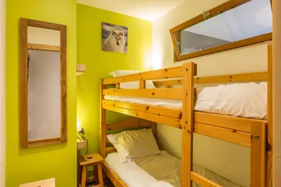 a bunk bed room with two bunk beds and a mirror at Apartment Periades - Central Chamonix Incredible Mountain Views in Chamonix-Mont-Blanc
