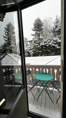 a table and chairs on a porch with a snow covered deck at Le Studio Alpin - Hyper centre Saint Gervais in Saint-Gervais-les-Bains