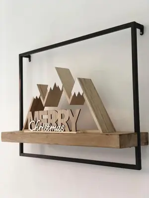 a shelf with a merry christmas sign on a wall at Le Studio Alpin - Hyper centre Saint Gervais in Saint-Gervais-les-Bains