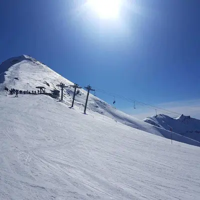 a group of people on a snow covered ski slope at Le Studio Alpin - Hyper centre Saint Gervais in Saint-Gervais-les-Bains