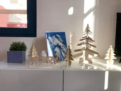 a white cabinet with christmas decorations on top of it at Le Studio Alpin - Hyper centre Saint Gervais in Saint-Gervais-les-Bains