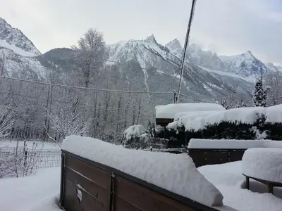 a snow covered balcony with a view of mountains at Chalet Les Lupins in Chamonix-Mont-Blanc
