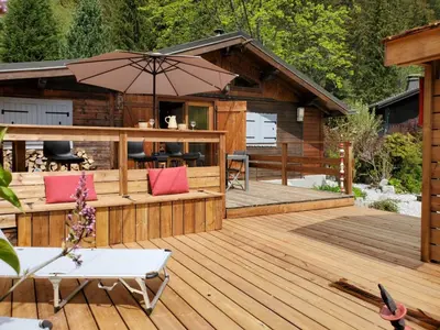 a deck with an outdoor seating area with an umbrella at Chalet Les Lupins in Chamonix-Mont-Blanc