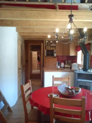 a kitchen with a red table and chairs in a room at Chalet Les Lupins in Chamonix-Mont-Blanc