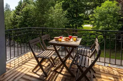 a table with a plate of food on a balcony at Le Paradis 15 Apartment - Chamonix All Year in Chamonix-Mont-Blanc