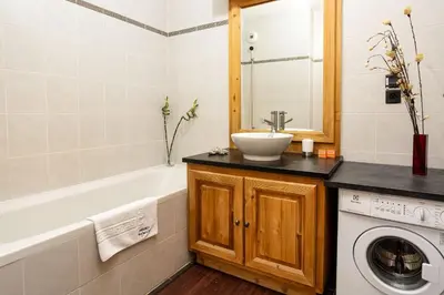 a bathroom with a sink and a washing machine at Le Paradis 15 Apartment - Chamonix All Year in Chamonix-Mont-Blanc