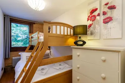 a bedroom with two bunk beds and a desk at Le Paradis 15 Apartment - Chamonix All Year in Chamonix-Mont-Blanc