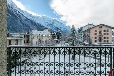a view from a balcony of a city with snow covered mountains at Hotel Le Chamonix in Chamonix-Mont-Blanc