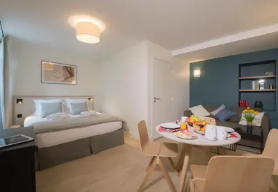 a hotel room with a bed and a table with a breakfast at Le Génépy - Appart'hôtel de Charme in Chamonix-Mont-Blanc