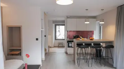 a kitchen with a counter and stools in a room at Le Génépy - Appart'hôtel de Charme in Chamonix-Mont-Blanc