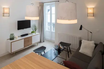 a living room with a couch and a tv at Le Génépy - Appart'hôtel de Charme in Chamonix-Mont-Blanc