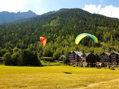 two kites flying over a field with a mountain at Le Chamois 5E Balcon panoramique MontBlanc avec parking gratuit in Chamonix-Mont-Blanc