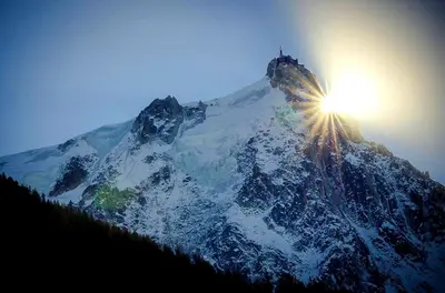 a mountain with the sun on top of it at Le Chamois 5E Balcon panoramique MontBlanc avec parking gratuit in Chamonix-Mont-Blanc