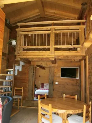 a wooden cabin with a table and a bunk bed at Les Chalets du Bonheur in Les Houches