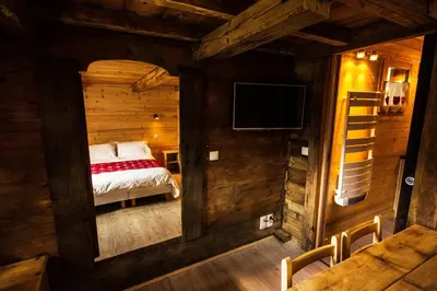 a bedroom with a bed in a wooden cabin at Les Chalets du Bonheur in Les Houches